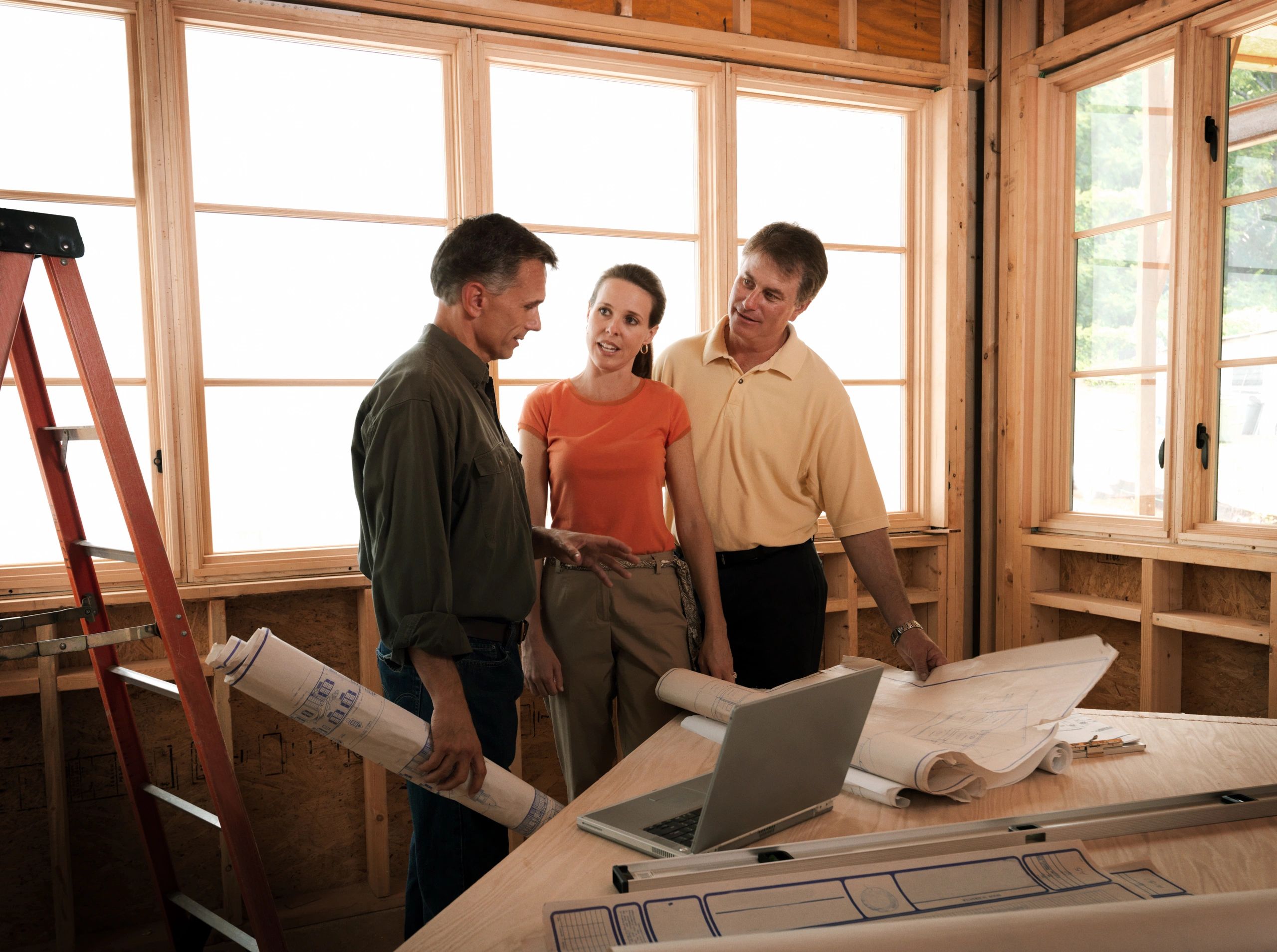 Homeowners consulting with contractor at a renovation site