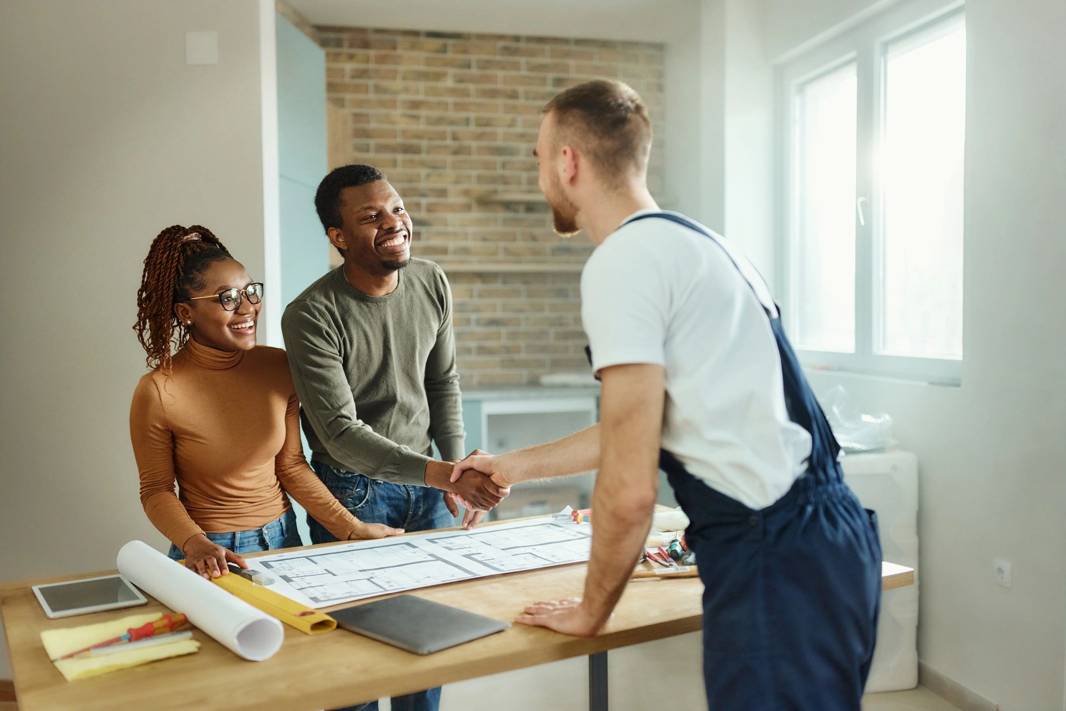 Homeowner shaking hands with a contractor after agreeing on a project