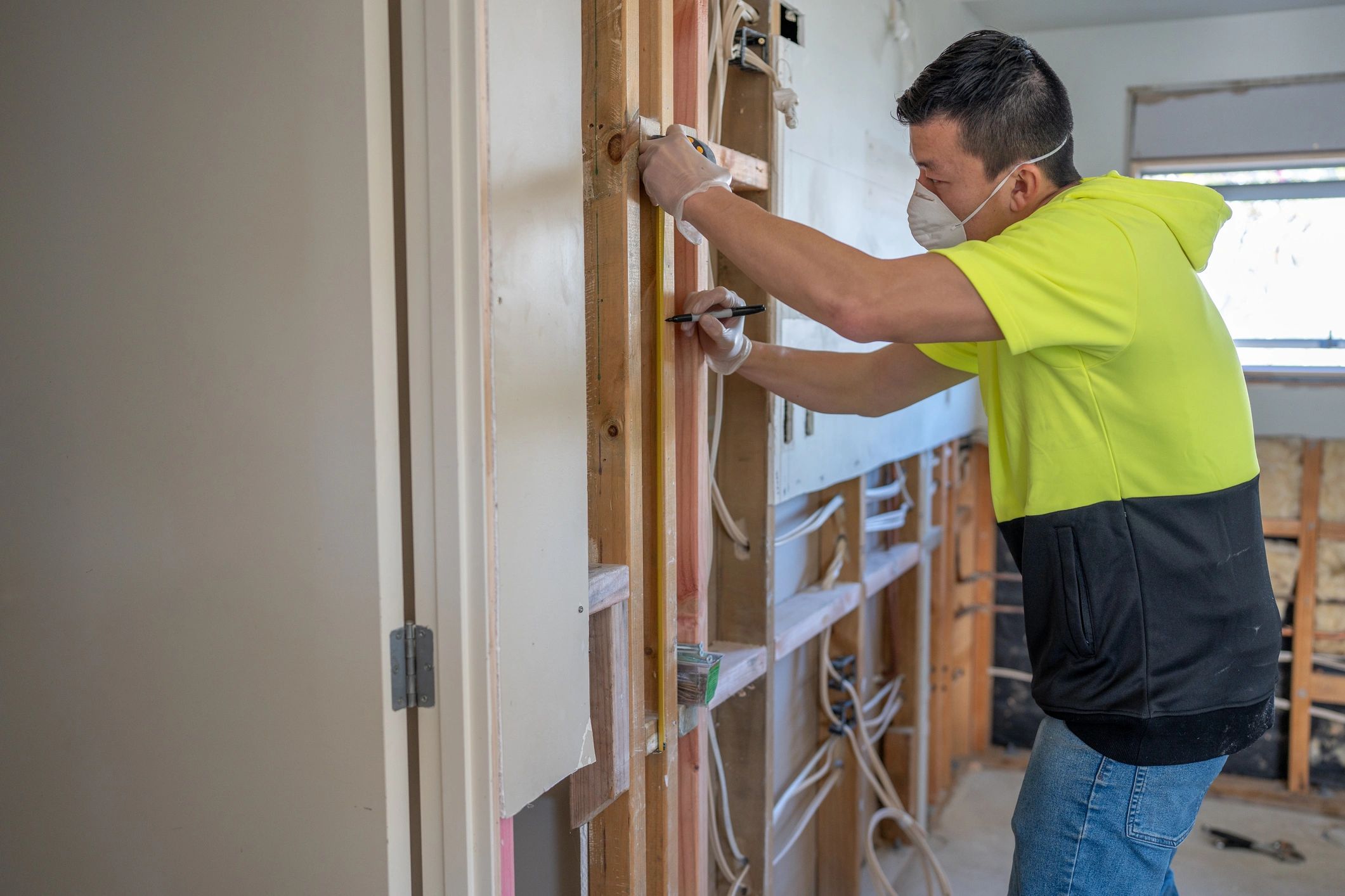 Contractor measuring interior framing during a renovation